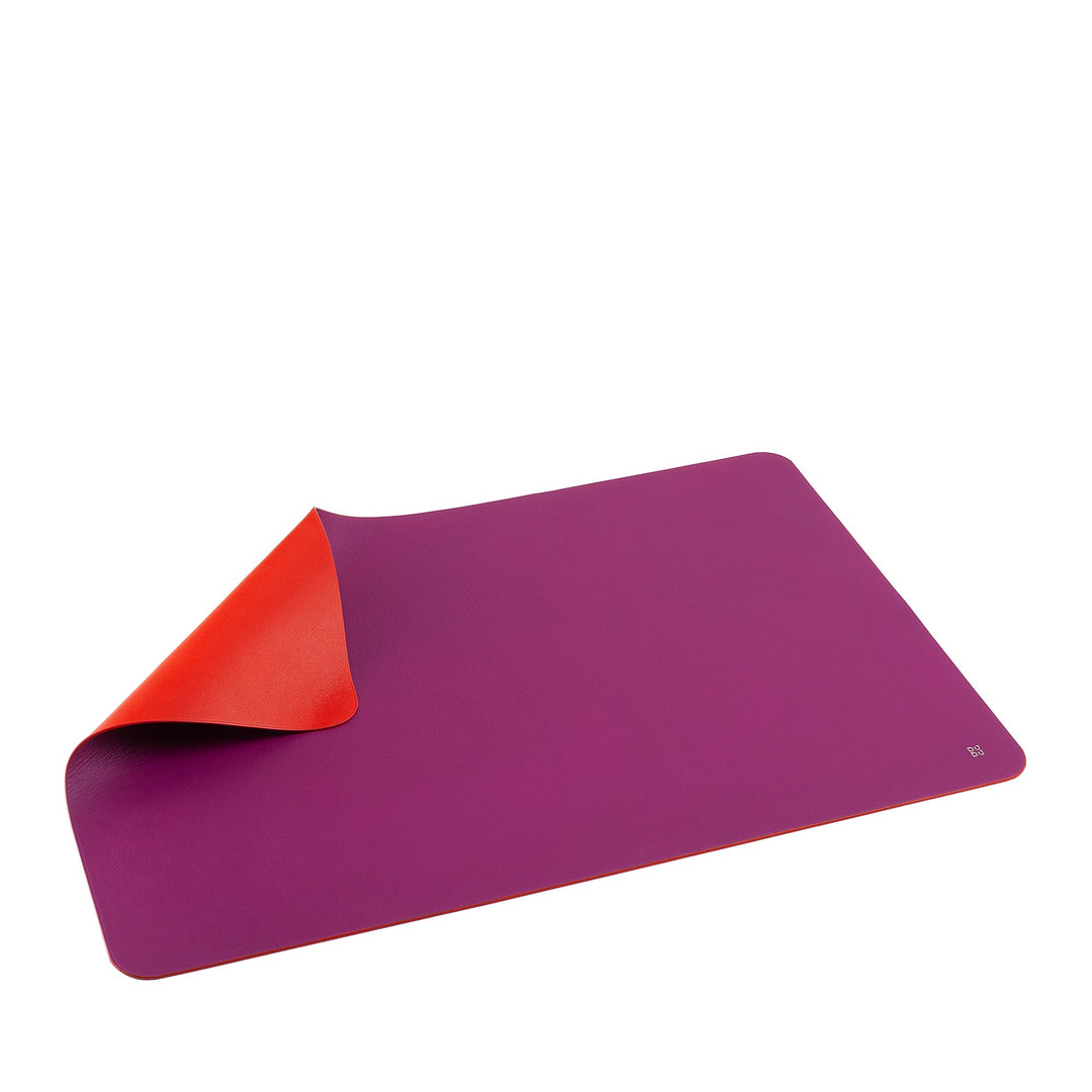Purple and red yoga mat rolled at one corner on a white background