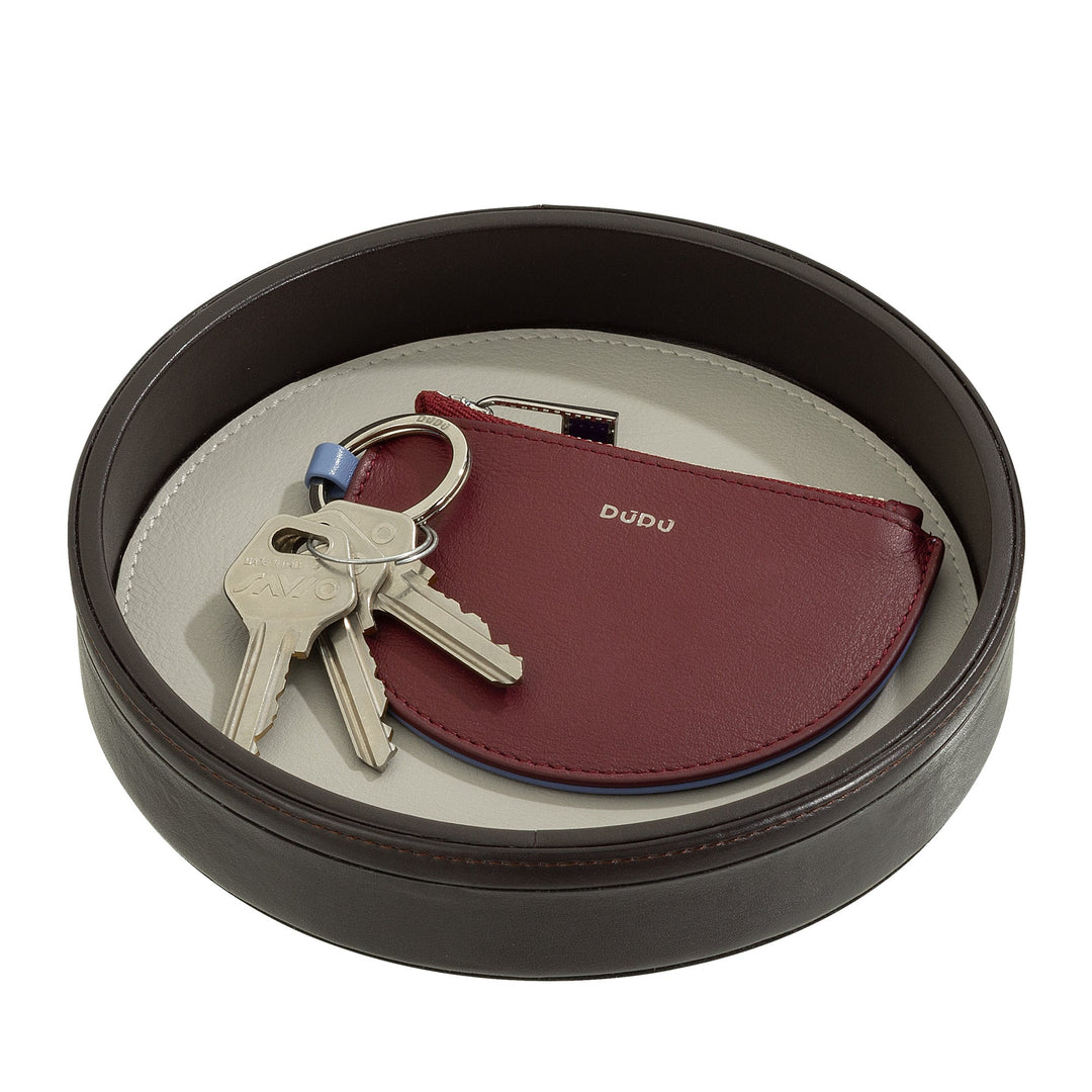 Round leather tray holding a set of keys and a red coin purse