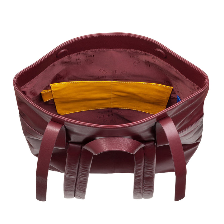 Open maroon leather handbag showing yellow interior pocket and multiple compartments