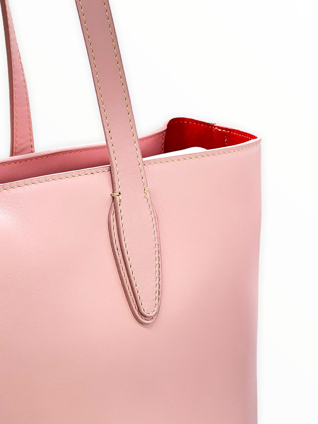 Pink leather tote bag with red interior and long handles