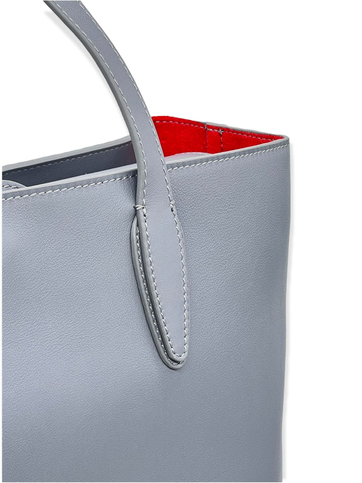 Close-up of a gray leather tote bag with a red interior