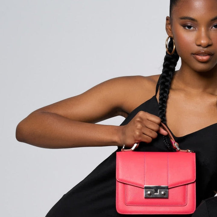 Woman holding pink handbag in black dress