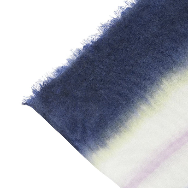 Close-up of a gradient navy to white fringed scarf with soft texture