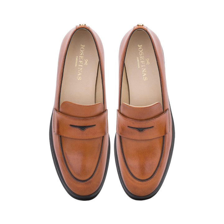 Top view of brown leather slip-on loafers with black trim accents