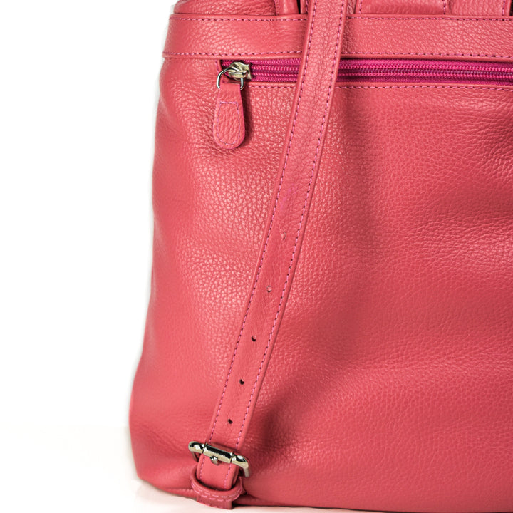 Close-up of a pink leather handbag with a zipper and strap