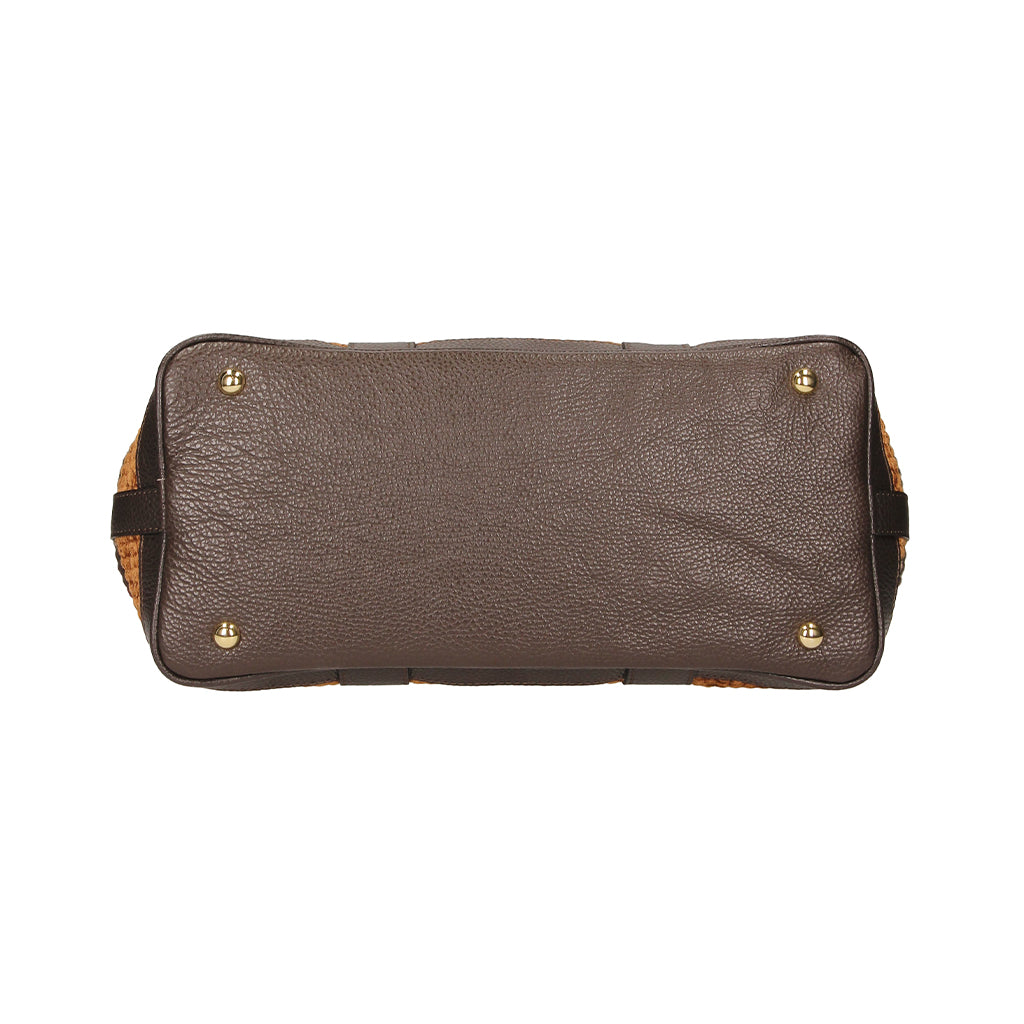 Brown leather handbag bottom view with metal feet and textured pattern