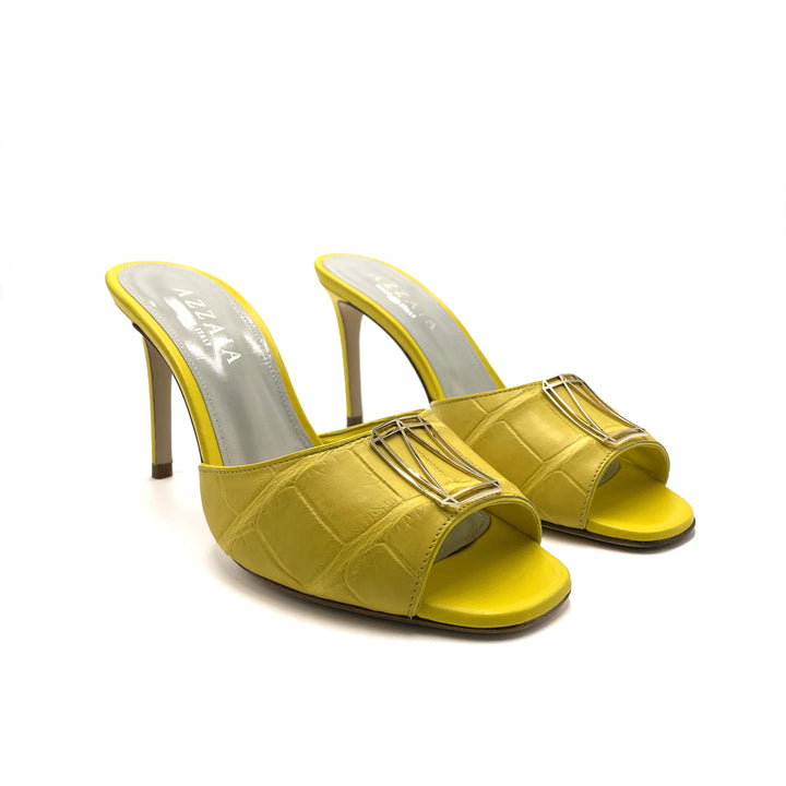 Yellow high-heeled sandals with open toes and silver accents on a white background