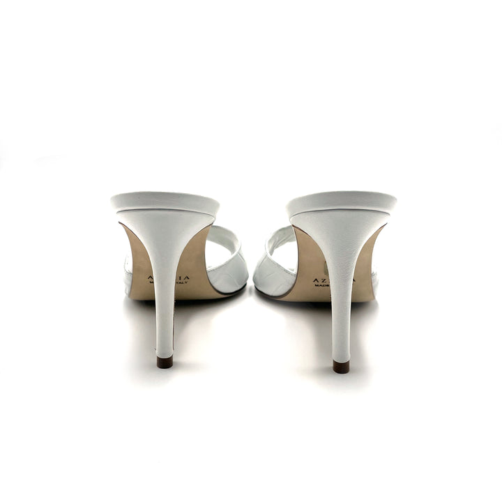 White high-heeled sandals with open-toe design, viewed from the back, on a white background