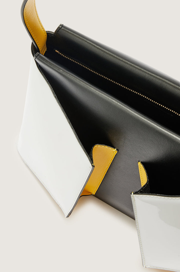 Stylish black, white, and yellow leather crossbody bag with sleek design and open compartments