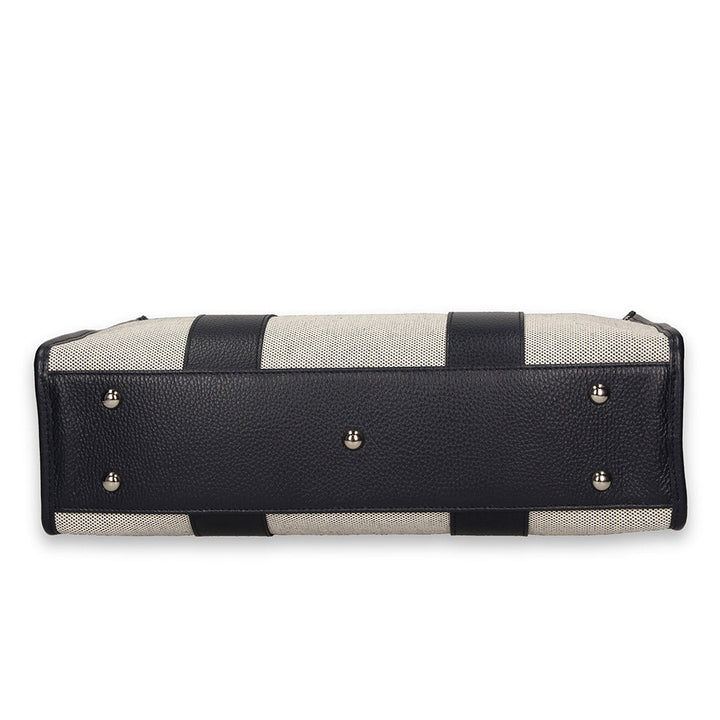 Bottom view of a black and white striped leather handbag with metal studs