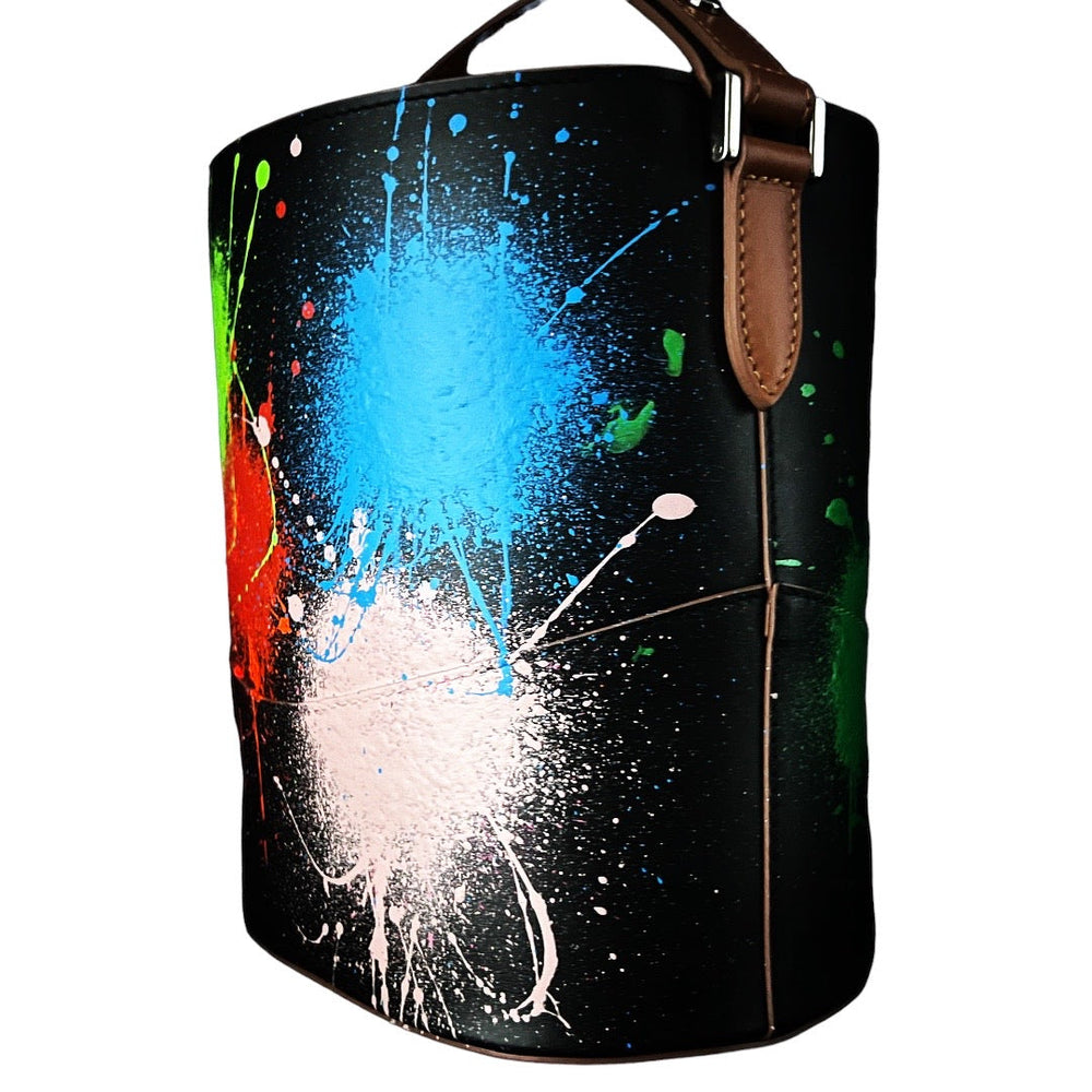Colorful paint splatter design on black leather bucket bag with brown leather trim