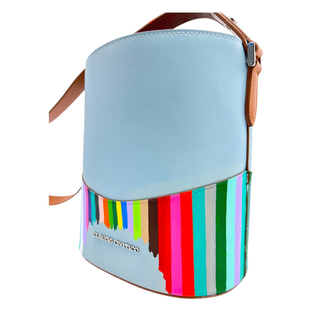 Light blue leather bucket bag with colorful vertical stripes and brown strap