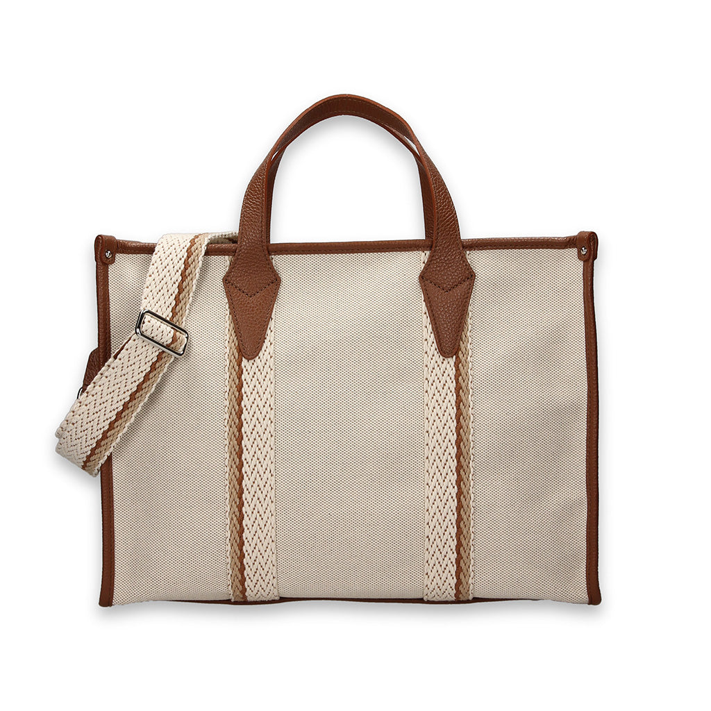 Beige canvas tote bag with brown leather handles and adjustable shoulder strap