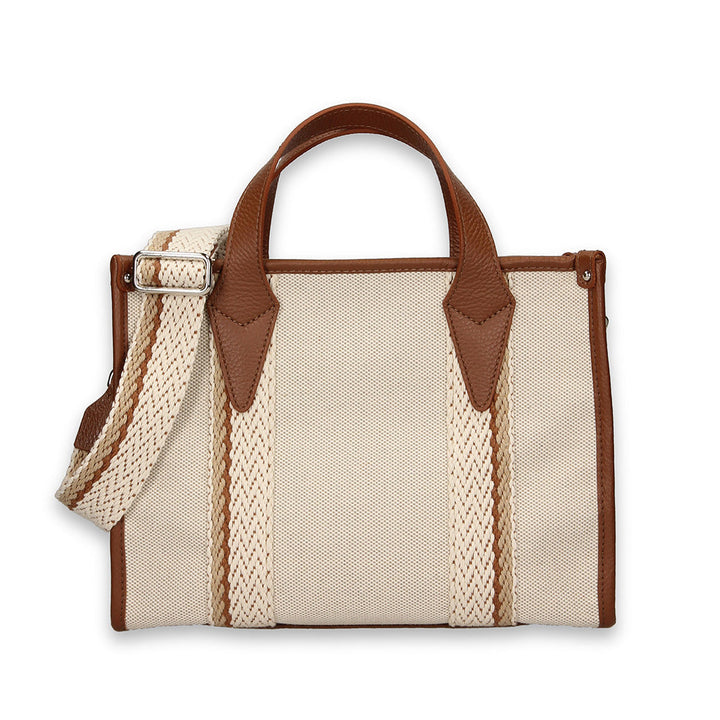 Tan canvas tote bag with brown leather handles and an adjustable woven shoulder strap