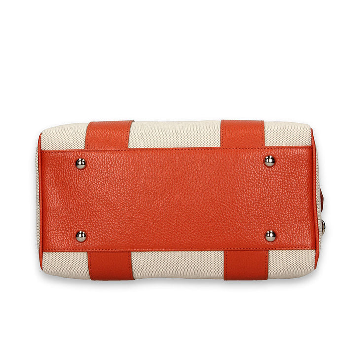 Top-down view of a stylish orange and beige leather handbag with metal studs detailing