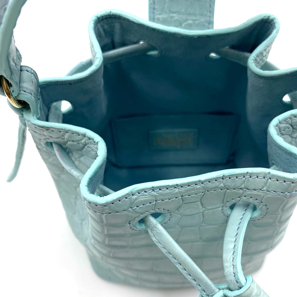 Light blue drawstring bucket handbag with a crocodile texture and open top view