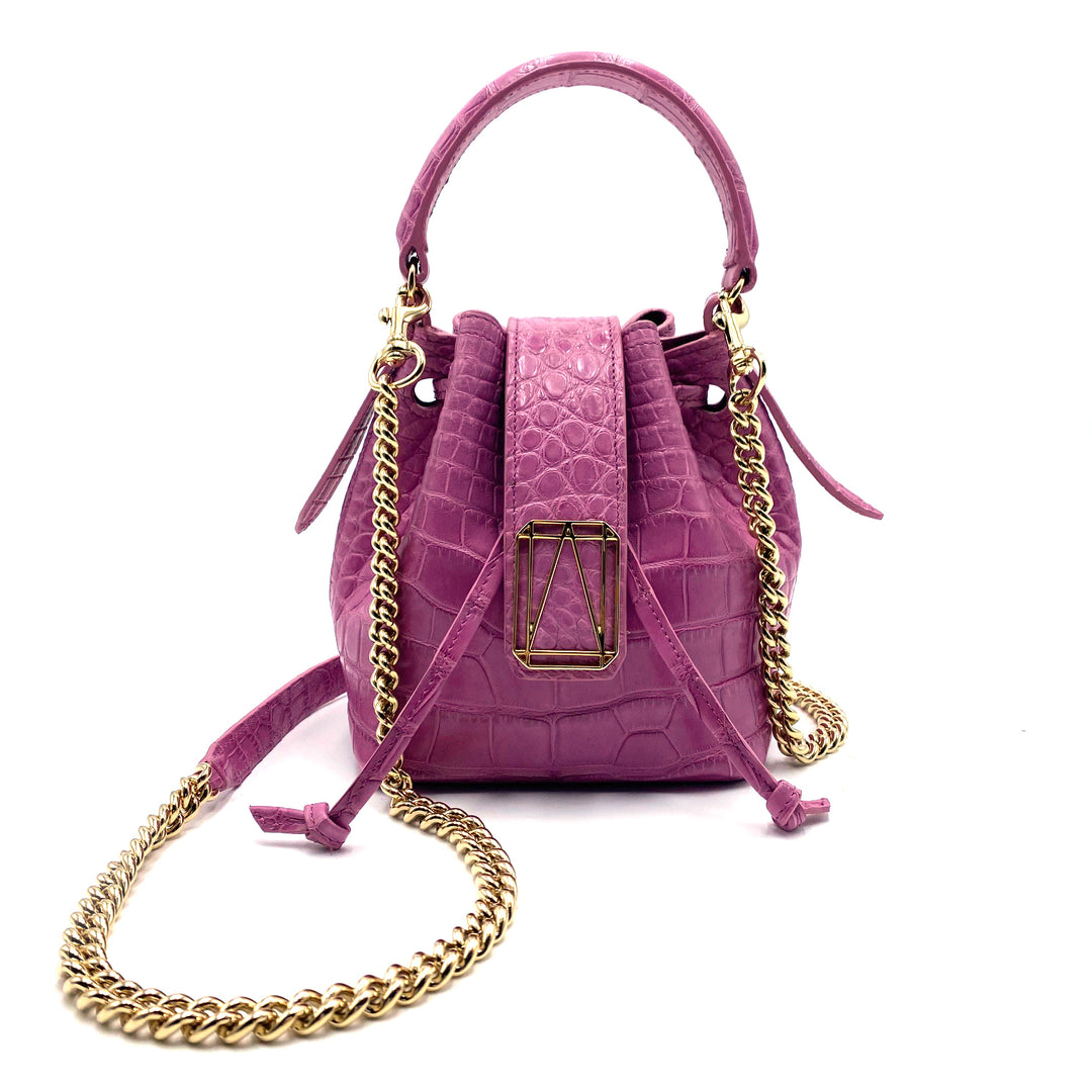 Pink designer handbag with gold chain straps and textured leather finish