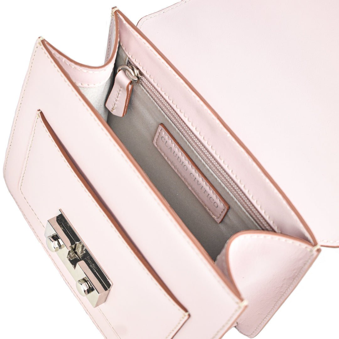 Open light pink leather handbag showing interior compartments and metal clasp