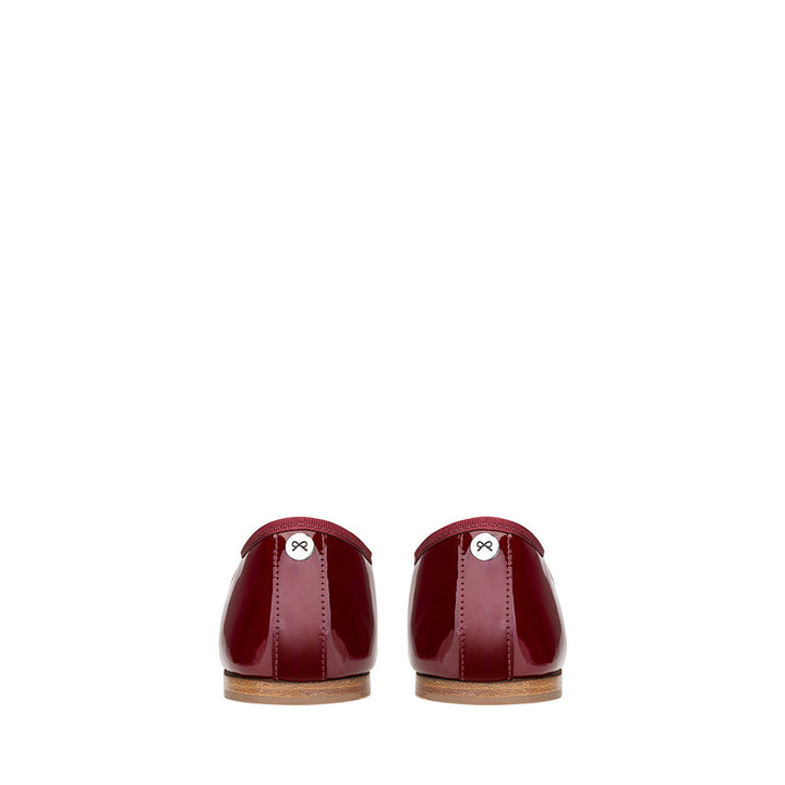Rear view of glossy burgundy leather shoes with wooden soles