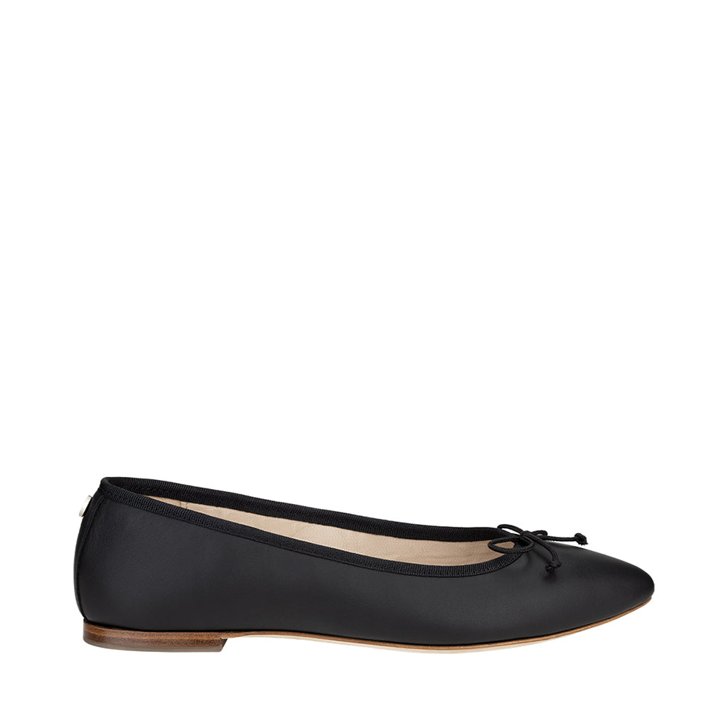 Black ballet flat shoe with bow detail and wooden sole on white background